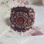 Bracelet Belle romance brodé avec des disques en Nacres Acajou et Prune. Orné de facettes, chatons, rocailles et navettes en Cristal. Le bord du bracelet est fini avec des perles Rose et Marron